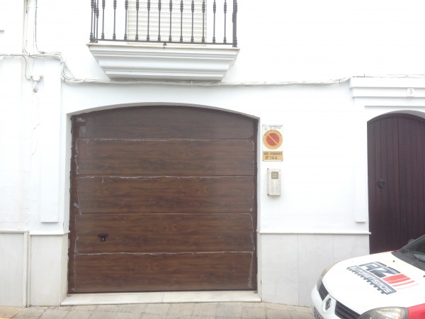Puerta seccional en fachada con arco segmentado en Cartaya